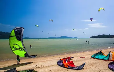 a group of people on a beach flying kites at Sunrise Beachfront Rawai in Ban Saiyuan (1)