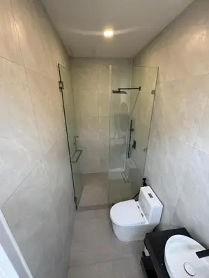 a bathroom with a shower and a toilet and a sink at Sunrise Beachfront Rawai in Ban Saiyuan (1)