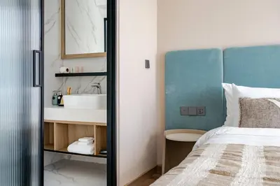 a bathroom with a bed and a sink in a room at Laya Resort Garden Escape- Tropical Serenity Suite in Layan Beach