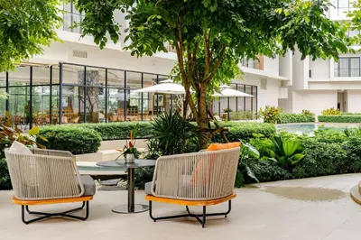 two chairs and a table in front of a building at Laya Resort Garden Escape- Tropical Serenity Suite in Layan Beach