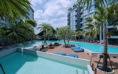 an empty pool at a hotel with palm trees at Tropical bliss & serenity in CityGate Resort near Kamala Beach in Phuket Town