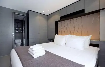 a bedroom with a large bed with white sheets and pillows at Tropical bliss & serenity in CityGate Resort near Kamala Beach in Phuket Town