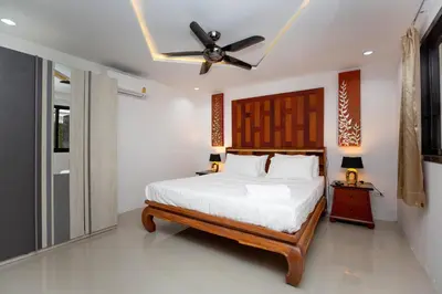 a bedroom with a bed and a ceiling fan at Waterfall House, 800 m to the Bang Tao beach in Ban Thalat Choeng Thale