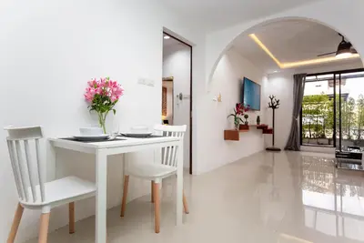 a white dining room with a white table and chairs at Waterfall House, 800 m to the Bang Tao beach in Ban Thalat Choeng Thale