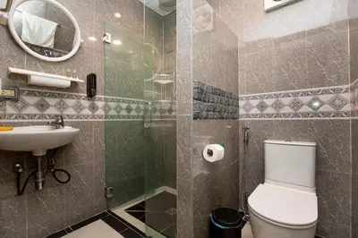 a bathroom with a toilet and a sink and a mirror at Waterfall House, 800 m to the Bang Tao beach in Ban Thalat Choeng Thale