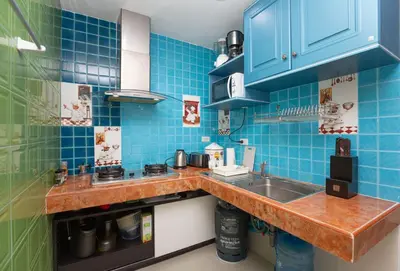 a kitchen with blue tiles on the wall and a sink at Waterfall House, 800 m to the Bang Tao beach in Ban Thalat Choeng Thale
