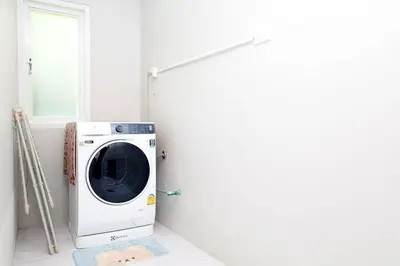 a washing machine in a room with a window at GA-GA-GA A cozy house in a quiet location on Bang Tao Beach in Ban Thalat Choeng Thale
