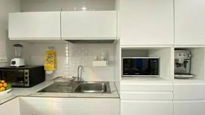 a white kitchen with a sink and a microwave at Cozy 2-bedrooms houses complex DIN, Bang Tao beach in Ban Thalat Choeng Thale