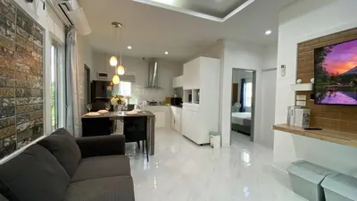 a living room and kitchen with a couch and a table at Cozy 2-bedrooms houses complex DIN, Bang Tao beach in Ban Thalat Choeng Thale