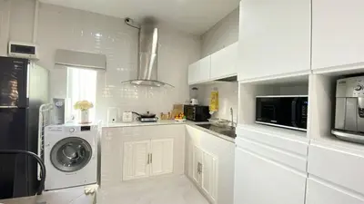 a white kitchen with a washing machine and a microwave at Cozy 2-bedrooms houses complex DIN, Bang Tao beach in Ban Thalat Choeng Thale