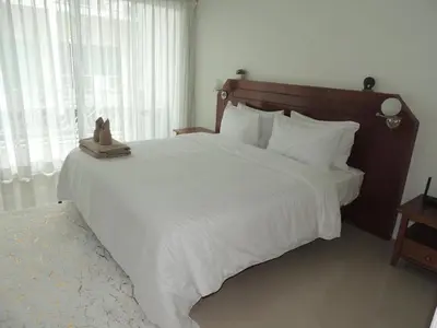 a bedroom with a large bed with white sheets at The Trend Villa in Kamala Beach