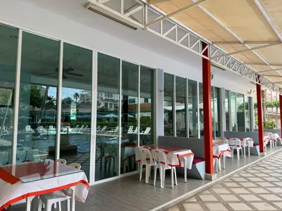 a restaurant with tables and chairs and a pool at The Trend Villa in Kamala Beach