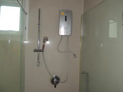 a shower in a bathroom next to a glass shower stall at The Trend Villa in Kamala Beach