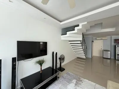 a living room with a staircase and a tv at The Trend Villa in Kamala Beach