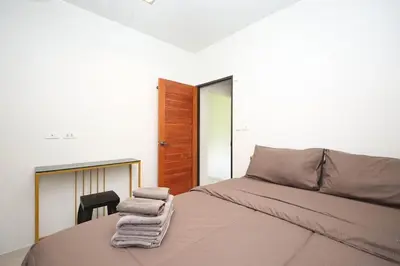 a bedroom with a bed with towels on it at BAN House, Bang Tao beach in Ban Thalat Choeng Thale