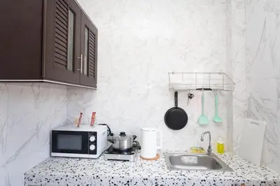 a kitchen counter with a microwave and a sink at DUCATTI apartments, 10 min to Bang Tao beach in Ban Thalat Choeng Thale