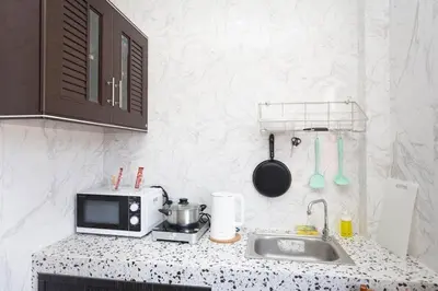a kitchen counter with a microwave and a sink at DUCATTI apartments, 10 min to Bang Tao beach in Ban Thalat Choeng Thale