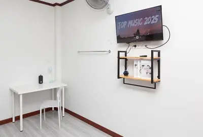 a room with a table and a tv on a wall at DUCATTI apartments, 10 min to Bang Tao beach in Ban Thalat Choeng Thale