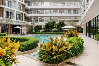 an apartment building with a swimming pool and plants at Laya Resort -Tropical Studio in Layan Beach