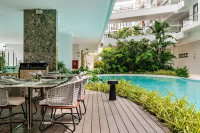 an outdoor patio with tables and chairs next to a swimming pool at Laya Resort -Tropical Studio in Layan Beach