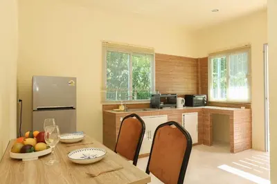 a kitchen with a table and chairs and a refrigerator at Yellow apartments 46,47 in Ban Thalat Choeng Thale