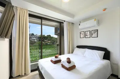 a bedroom with a bed with two towels on it at Comfy 1-BR room Mountain View, 5 min to Rawai Beach in Phuket Town