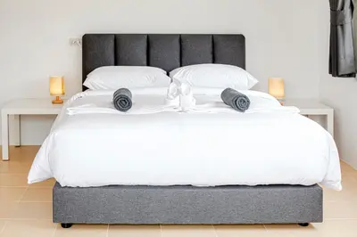 a bedroom with a large bed with white sheets and pillows at Stay White Orchid in Krabi town
