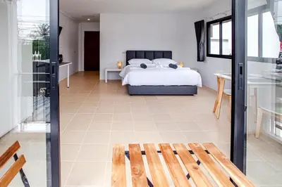 a bedroom with a bed and a glass door at Stay White Orchid in Krabi town