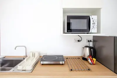 a kitchen with a counter with a microwave and a stove at Stay White Orchid in Krabi town