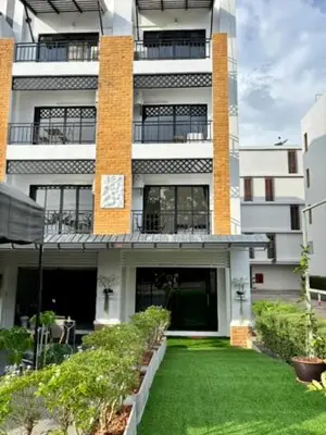 a large building with a lawn in front of it at Stay White Orchid in Krabi town