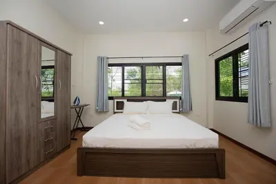 a bedroom with a large bed and two windows at 2 bedrooms house GREEN SALLY in Patong Beach
