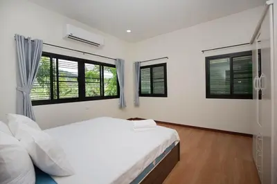 a white bedroom with a bed and windows at 2 bedrooms house GREEN SALLY in Patong Beach