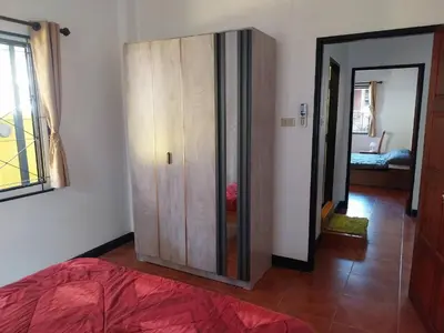 a bedroom with a wooden cabinet and a bed at House in the heart of Kamala in Kamala Beach