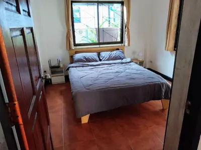 a small bedroom with a bed and a window at House in the heart of Kamala in Kamala Beach