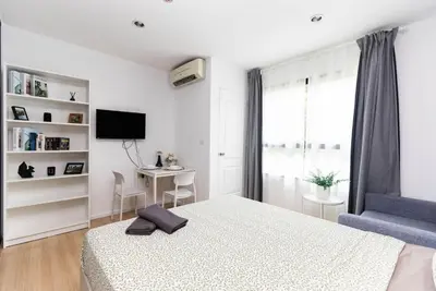a bedroom with a bed and a desk and a television at Zcape 1 bedroom apartment in Ban Thalat Choeng Thale