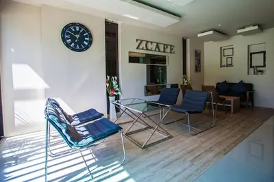 a living room with chairs and a clock on a wall at Zcape 1 bedroom apartment in Ban Thalat Choeng Thale