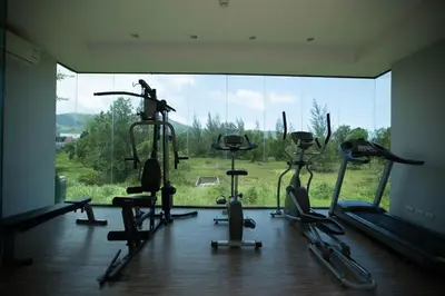 a gym with several exercise bikes and a large window at Zcape 1 bedroom apartment in Ban Thalat Choeng Thale