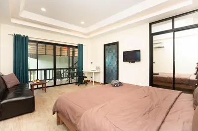 a bedroom with a large bed and a couch at Cat house, 5 min to the beach in Ban Thalat Choeng Thale