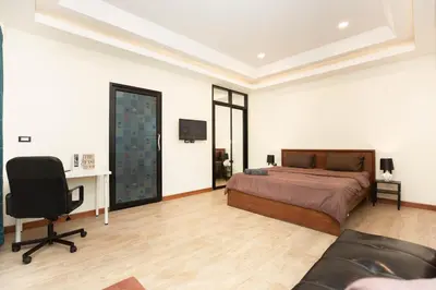 a bedroom with a bed and a desk and a chair at Cat house, 5 min to the beach in Ban Thalat Choeng Thale
