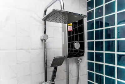 a shower with a shower head in a bathroom at Cat house, 5 min to the beach in Ban Thalat Choeng Thale