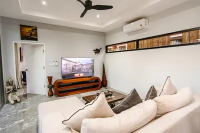 a living room with a white couch and a tv at Suwali Villa - 3 Bedroom Private Pool Villa in Ban Saiyuan (1)