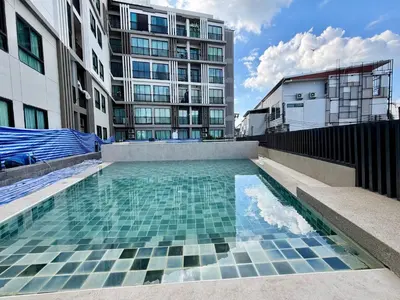 a swimming pool in front of a building at Z cape 1 one one in Laguna Phuket