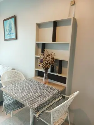 a dining room table with chairs and a book shelf at Z cape 1 two two in Ban Thalat Choeng Thale