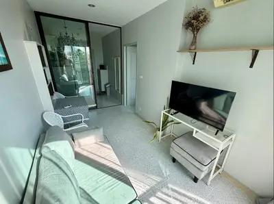 a living room with a flat screen tv and a couch at Z cape 1 two two in Ban Thalat Choeng Thale