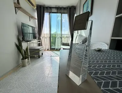 a room with a bed and a view of a balcony at Z cape 1 two two in Ban Thalat Choeng Thale