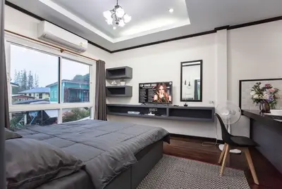 a bedroom with a bed and a desk and a window at Beautiful apartment in Ban Thalat Choeng Thale