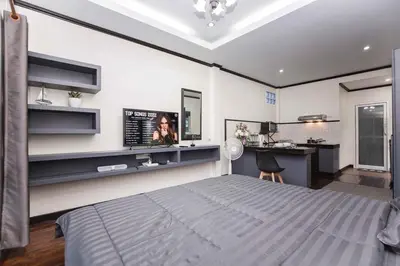 a bedroom with a bed and a desk in it at Beautiful apartment in Ban Thalat Choeng Thale