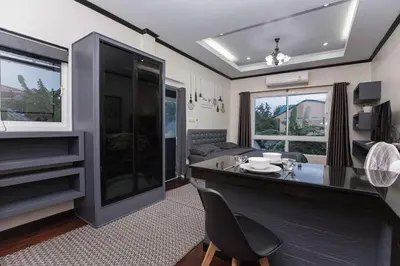 a living room with a desk and a large window at Beautiful apartment in Ban Thalat Choeng Thale
