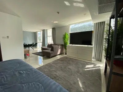 a bedroom with a bed and a couch and a television at Kris condo in Patong Beach