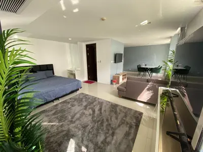 a bedroom with a bed and a couch and a table at Kris condo in Patong Beach